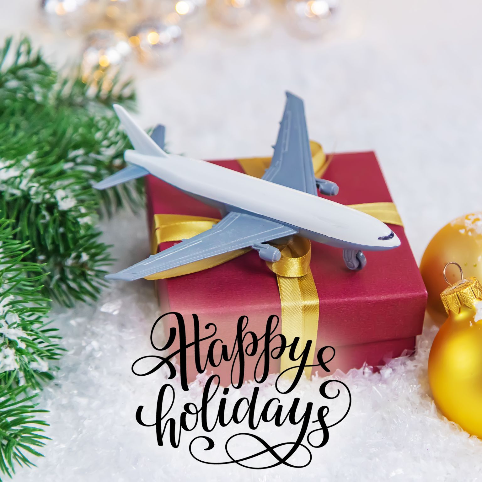 Orkal, Orkal Industries' aircraft-grade toy plane atop a red box, with assembly solutions inspired ribbon, amidst aviation compliant Christmas decor.