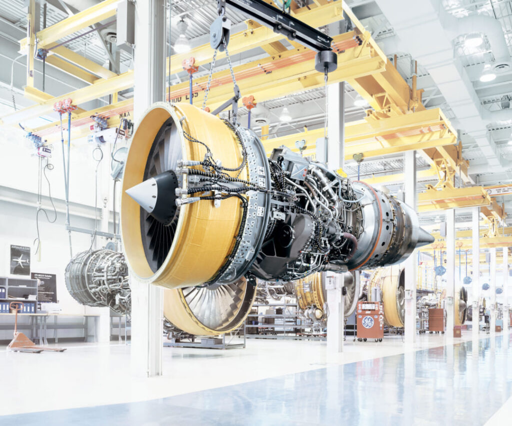A modern GE Standards Linecard assembly line in a brightly lit industrial plant with engines at various stages of completion.